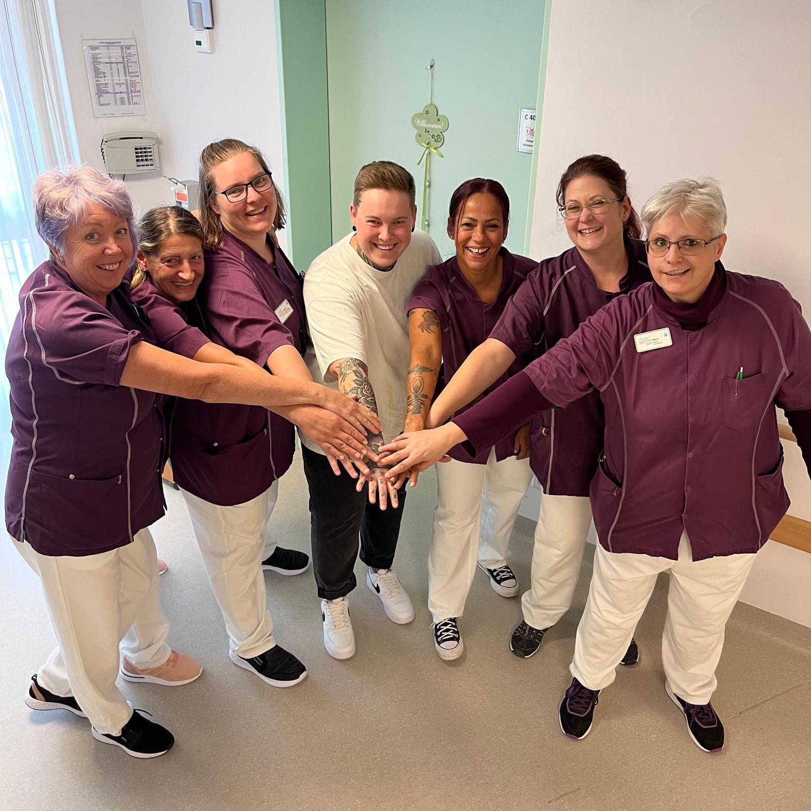 Team Team des Seniorenzentrum Hospital halten Hände zusammen