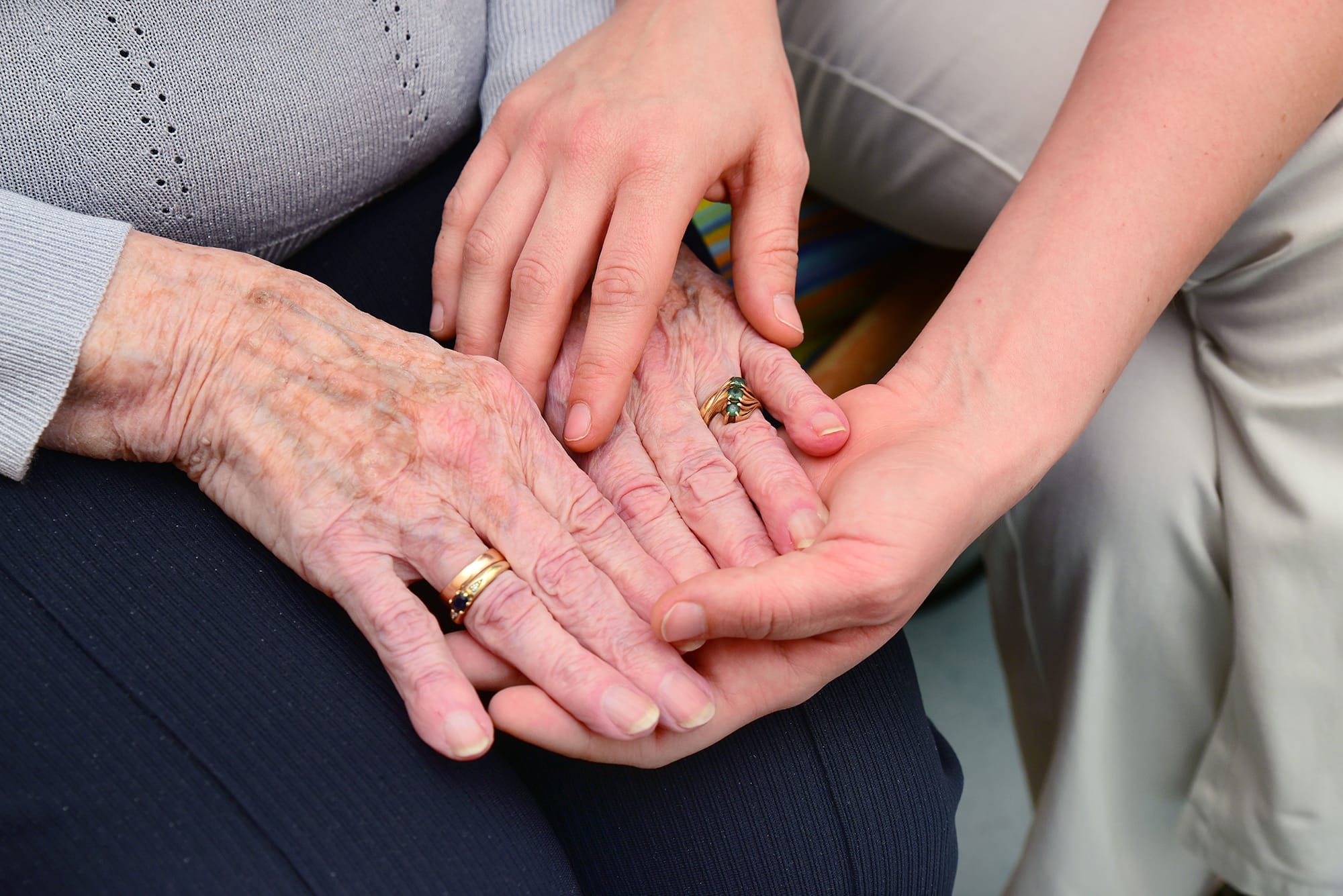 ältere und jüngere Hände halten einander