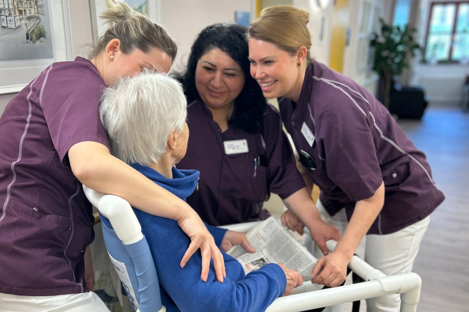 drei Pflegerinnen kümmern sich umn eine Bewohnerin